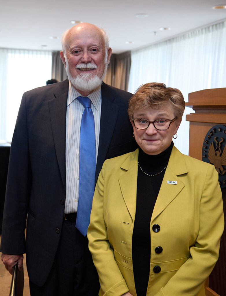 Man and woman standing side-by-side in front of a podium