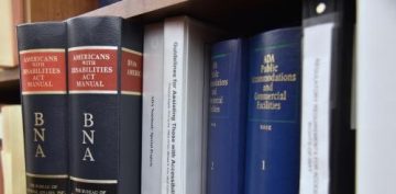 hardcover books on a shelf, spins facing. Feature titles such as "Americans with Disabilities Act"