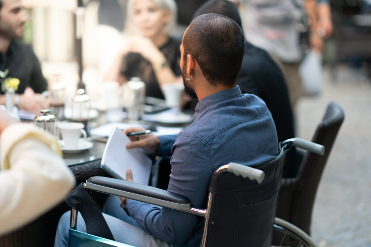 photo of a man in a wheelchair sitting at a table in a meeting