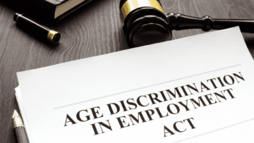 packet of papers on a desk that reads "age discrimination in the employment act," sitting next to a gavel