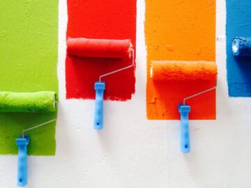 various colors of paint being brushed onto a wall