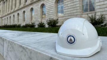 White hard hat resting on a marble wall outside a congressional office building
